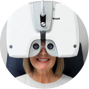 Smiling patient looking into a diagnostic instrument