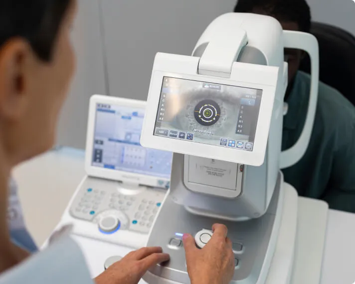Clinician operating a corneal imaging instrument during an eye examination