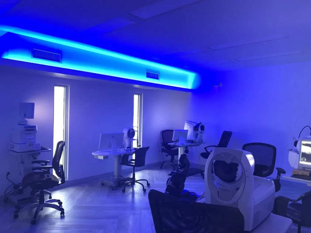 Examination room lit with blue accent lighting and diagnostic equipment