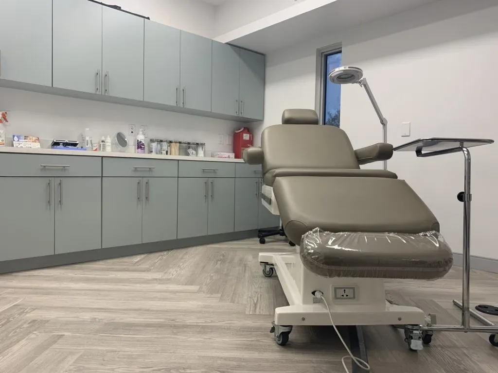 Procedure room with a reclining treatment chair and surgical light