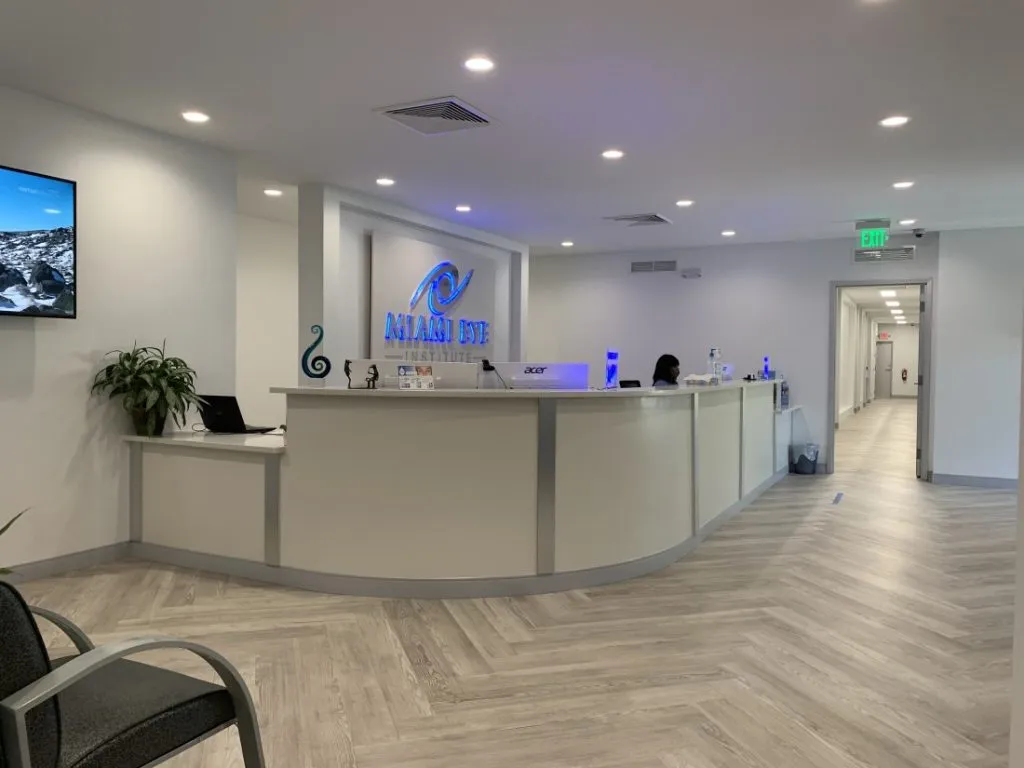 Reception desk and waiting area with the Miami Eye Institute logo on the wall
